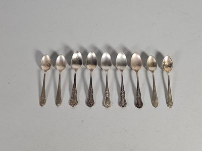 six cuillères en argent sont alignées sur une table