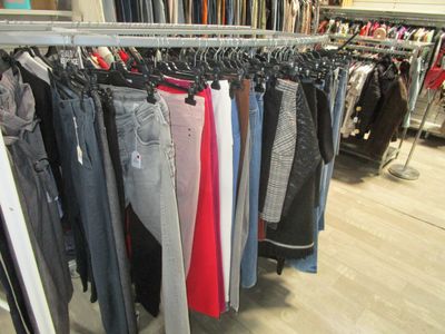 beaucoup de vêtements suspendus à une étagère dans un magasin