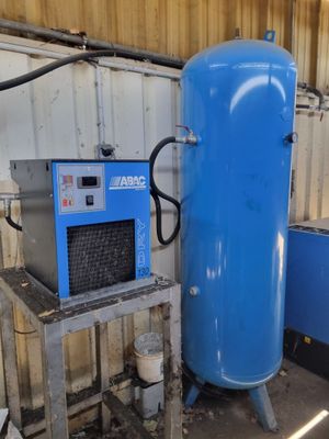 a large blue tank sitting next to a blue machine