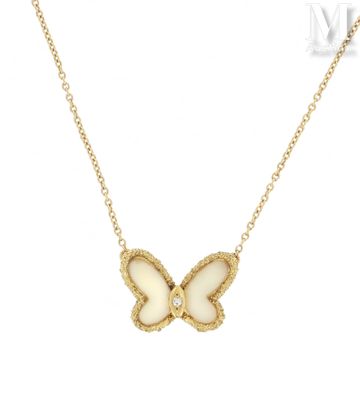 un collier en or avec un papillon blanc suspendu à une chaîne