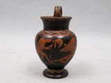 a black and red vase with a bird on it