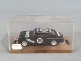 a small black car in a clear box on a table