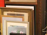 a lot of picture frames on the floor in this room