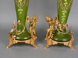 two green vases with gold decorations on them