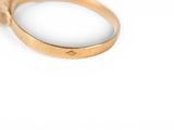 an image of a close up of a gold ring on a white surface