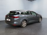 the rear end of a grey car in a room with a ceiling fan