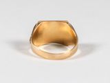 a close up of a gold ring on a white surface