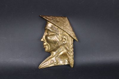 brass bust of a man with a feathered hat on his head