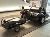 a motorcycle with a trailer attached to it in a garage