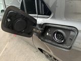 a silver car with a gas pump attached to it ' s side