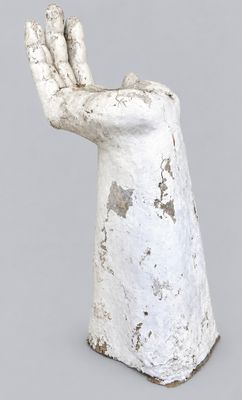 concrete sculpture of a hand holding something in it ' s palm