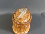 a small wooden box with a feather on it