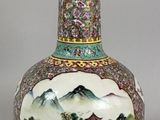 a vase with a painting on it sitting on a table