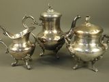three silver teapots sitting on a table next to each other