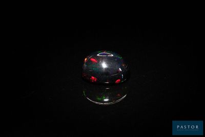 an image of a black and red glass ball on a black surface