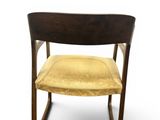 a close up of a chair with a yellow seat on a white background
