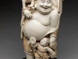 an ivory figurine of a laughing buddha holding a baby