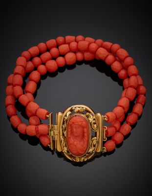 un bracelet en or et corail muni d'un fermoir orné d'une pierre rouge