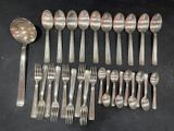 many spoons and forks laid out on the table