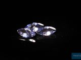 a close up of two blue sapphires on a black surface