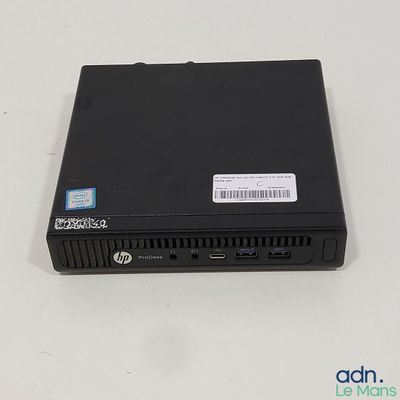 the small black computer is on a white surface with a sticker on it