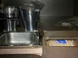 a kitchen with a sink and a counter with a lot of items in it