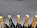 six bottles of champagne are lined up in a row