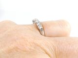 a person holding a diamond ring on their finger