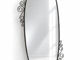a black oval mirror hanging on the wall