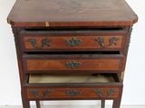 a small wooden table with three drawers on it