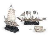 trois maquettes de bateaux en métal sont posées les unes à côté des autres sur une surface blanche