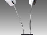 une paire de lampes chromées posées sur un pied noir, sur fond gris