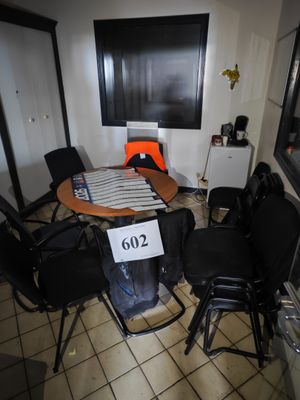 une pièce équipée d'une table, de chaises et d'un réfrigérateur