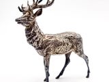 statue d'un cerf debout sur une surface blanche devant un fond blanc