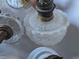 several old fashioned lamps that are on a white table