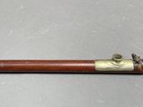 an old wooden pipe with brass fittings on a gray surface