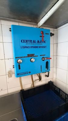a blue box in the corner of a public restroom