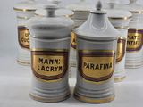 several white and gold canisters are lined up on a white surface