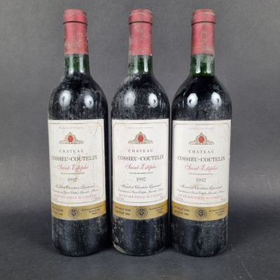 three bottles of red wine sitting next to each other on a table
