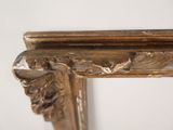 a close up of a gold frame on a white wall