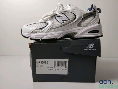 une boîte sur laquelle est posée une paire de chaussures New Balance