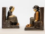deux figurines représentant une femme assise sur une chaise