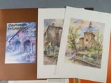 three cards with watercolor paintings on them on a table