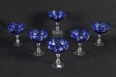 six blue glass goblets sitting on top of a black table