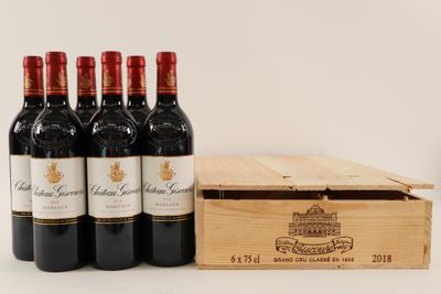 six bouteilles de vin rouge dans un coffret en bois, à côté d'une bouteille de vin
