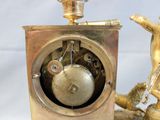 a clock that is sitting on a table next to a figurine