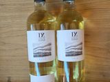 two bottles of wine sitting on top of a wooden shelf next to each other