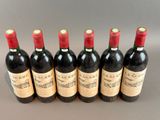 six bottles of wine lined up in a row on a table