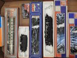 une boîte contenant un assortiment de circuits de trains miniatures dans leur emballage d'origine