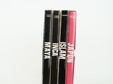 trois livres sont empilés sur une surface blanche